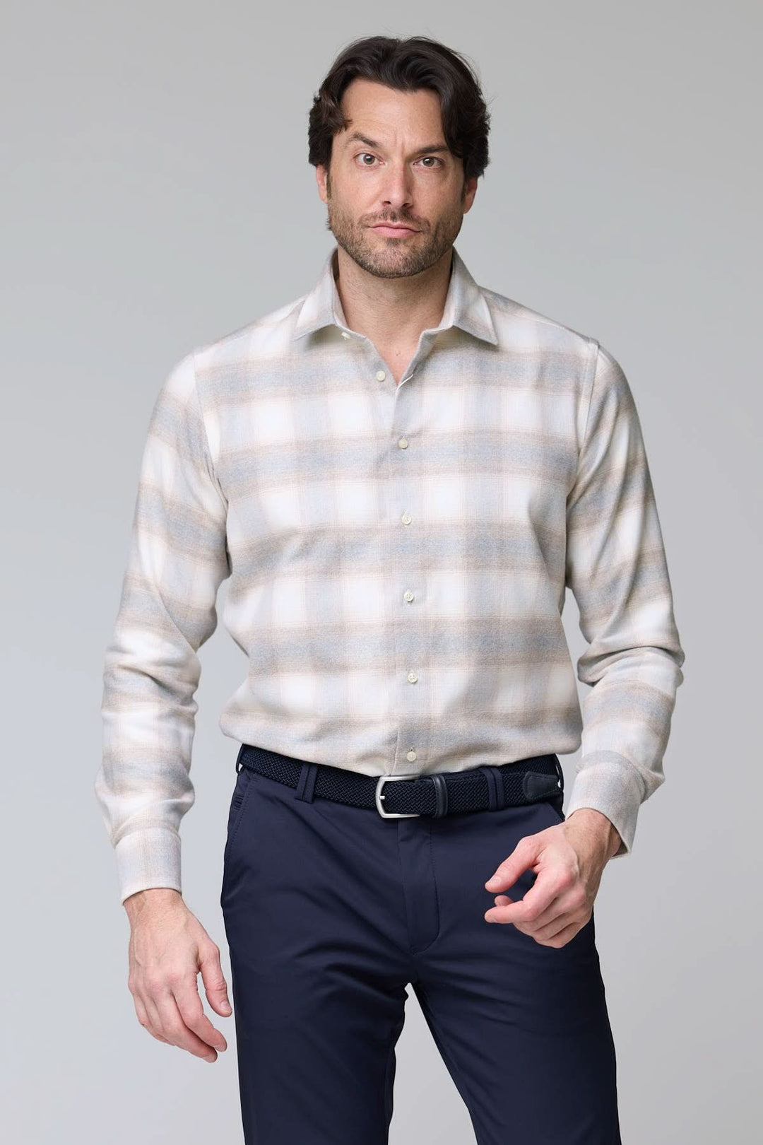 Homme portant une chemise à carreaux doux en flanelle, coupe moderne, couleur ton sur ton, avec boutons nacrés discrets, look élégant et casual.