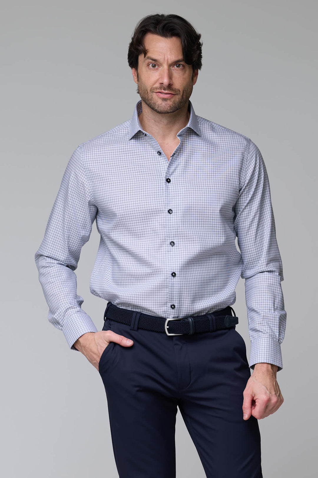 Homme portant une chemise à carreaux fins, manches longues, coupe ajustée élégante, idéale pour un look professionnel et décontracté.