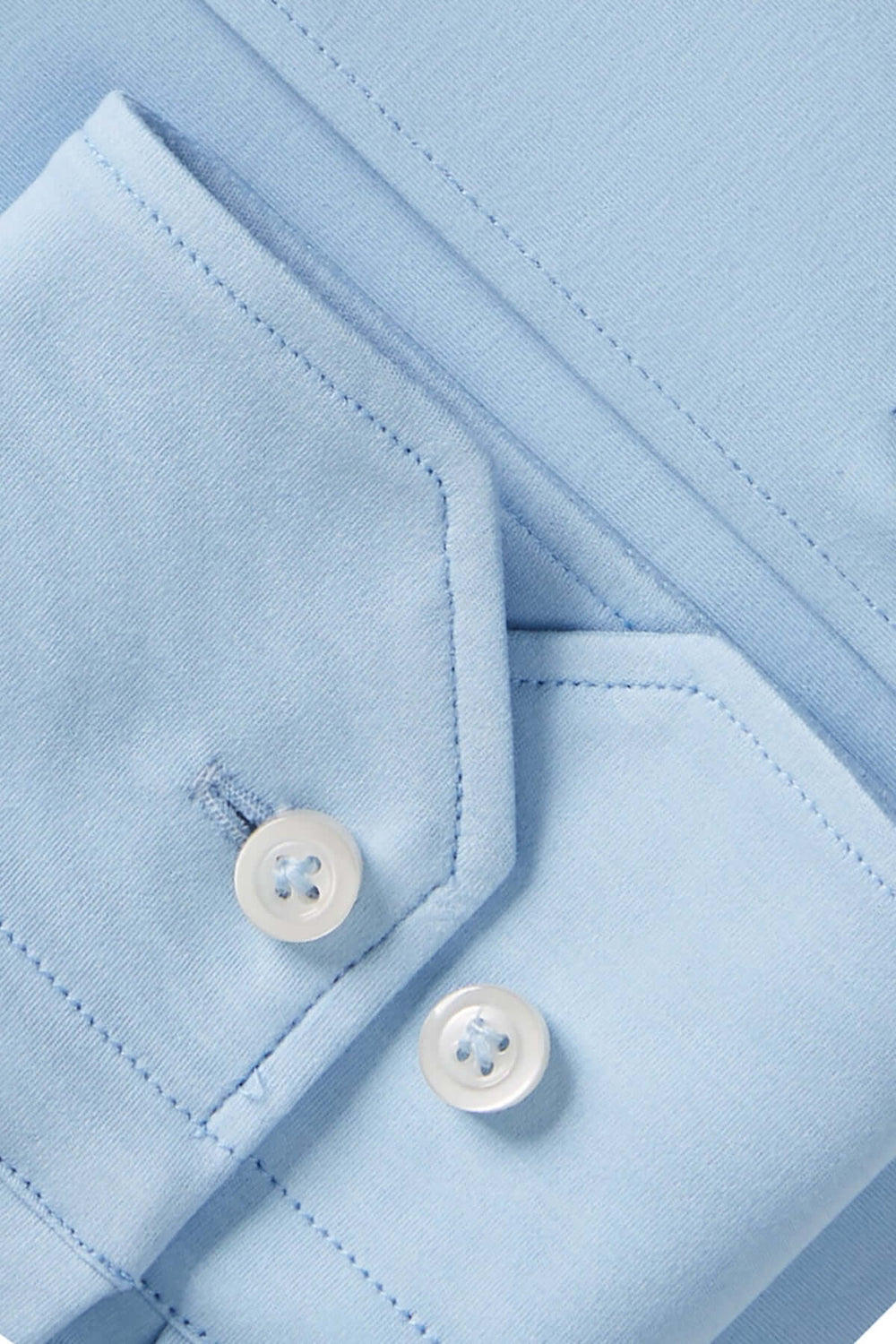 Détails d'une chemise classique bleue avec col structuré et boutons assortis.
