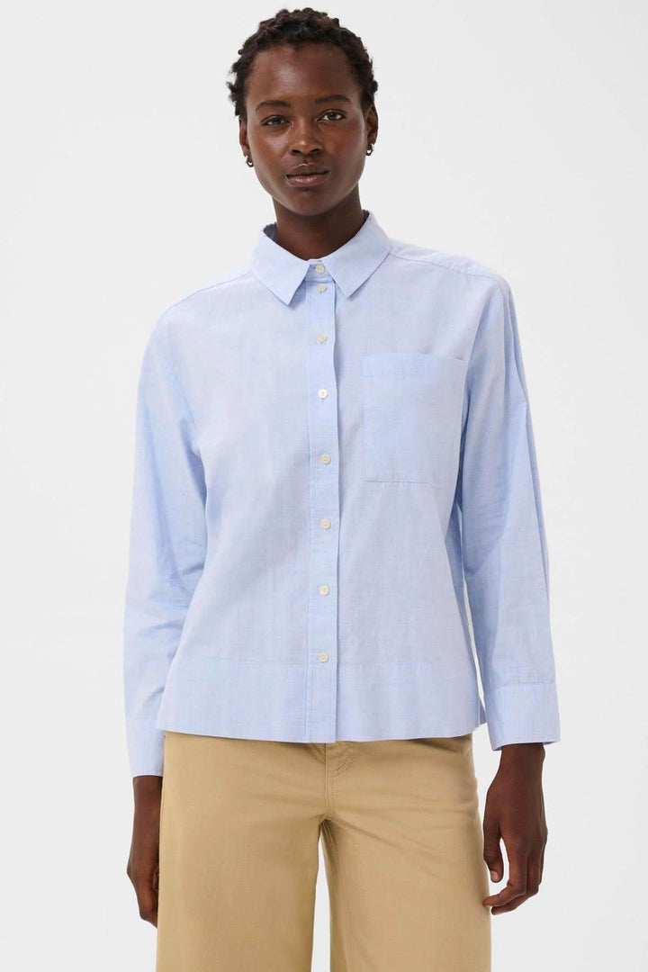Femme portant une chemise classique en popeline Nenee avec col rigide et coupe droite, idéale pour une tenue de bureau ou décontractée.
