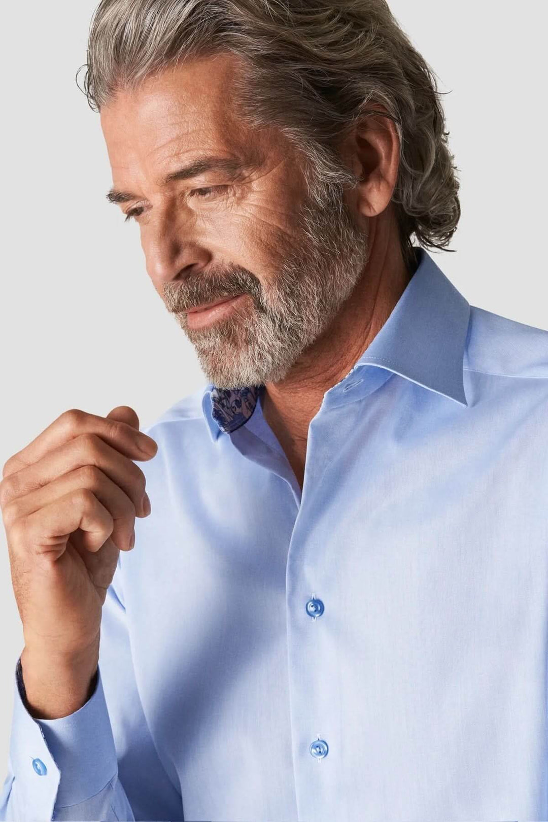 Homme portant une chemise en coton signature à col italien bleue, style élégant et raffiné.
