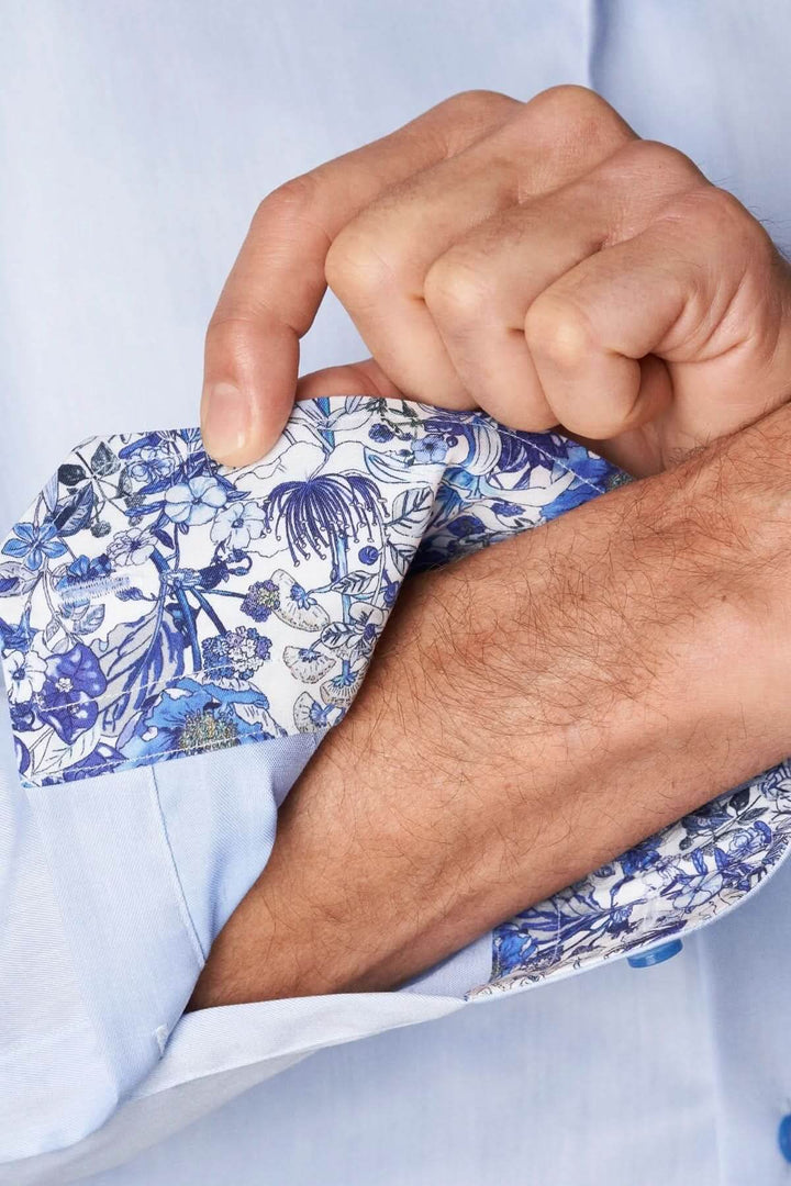 Détail manchette chemise en coton signature à col italien avec motif floral intérieur.