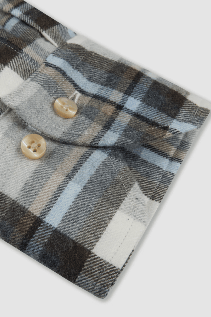 Détail d'une chemise en flanelle à carreaux avec boutons en nacre et col boutonné.