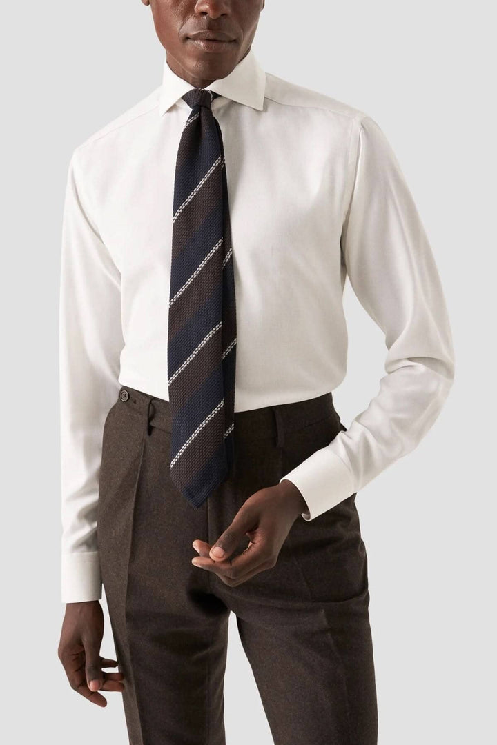 Chemise élégante blanche avec cravate rayée, parfaite pour un look professionnel chic.