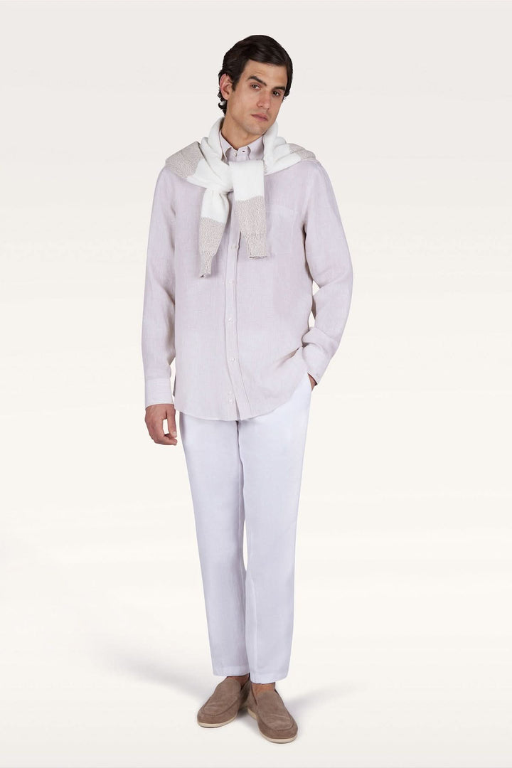 Homme portant une chemise en lin Soffio avec pantalon blanc et pull noué sur les épaules