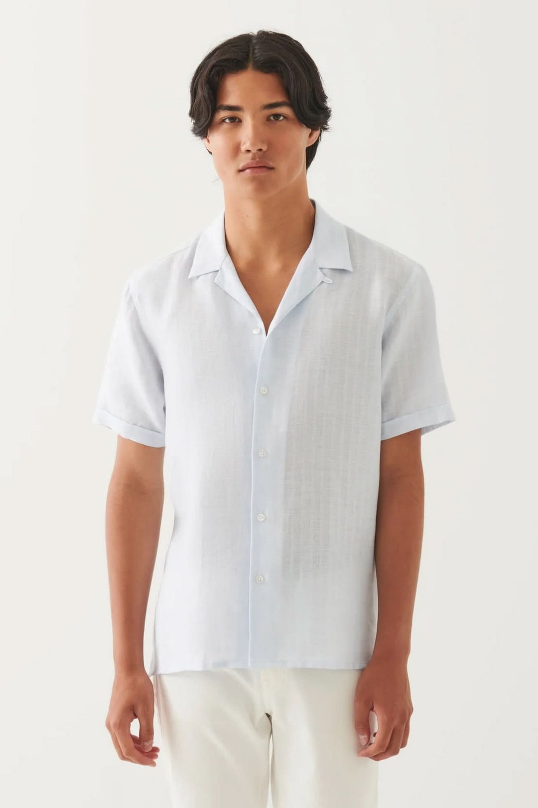 Chemise en lin à col camp, légère et texturée, parfaite pour les journées ensoleillées, portée par un modèle.
