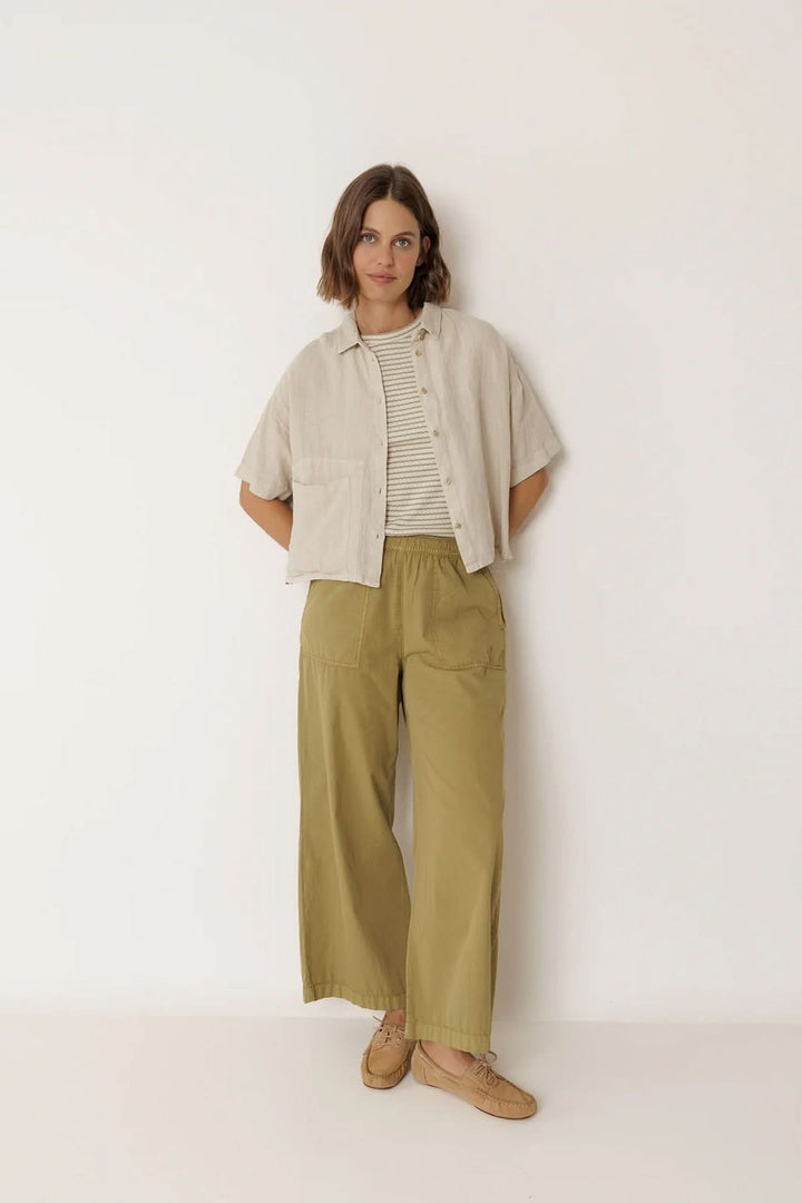 Femme portant une chemise en lin à coupe décontractée avec un pantalon kaki, style estival élégant.