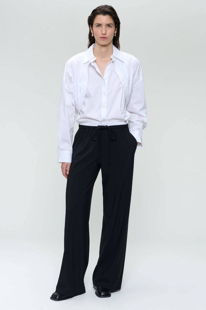 Chemise en popeline blanche avec pantalon noir, style ample et moderne, parfaite pour un look structuré.