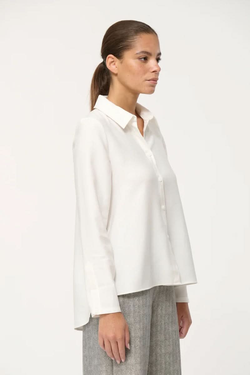 Chemise fluide blanche à col classique, coupe ample, pour un look élégant et confortable au quotidien.