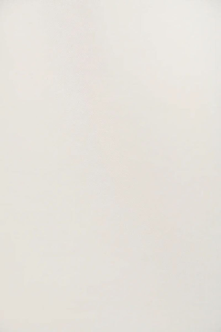 Chemise fluide blanche avec coupe ample, col classique et fermeture boutonnée, style élégant et confortable.