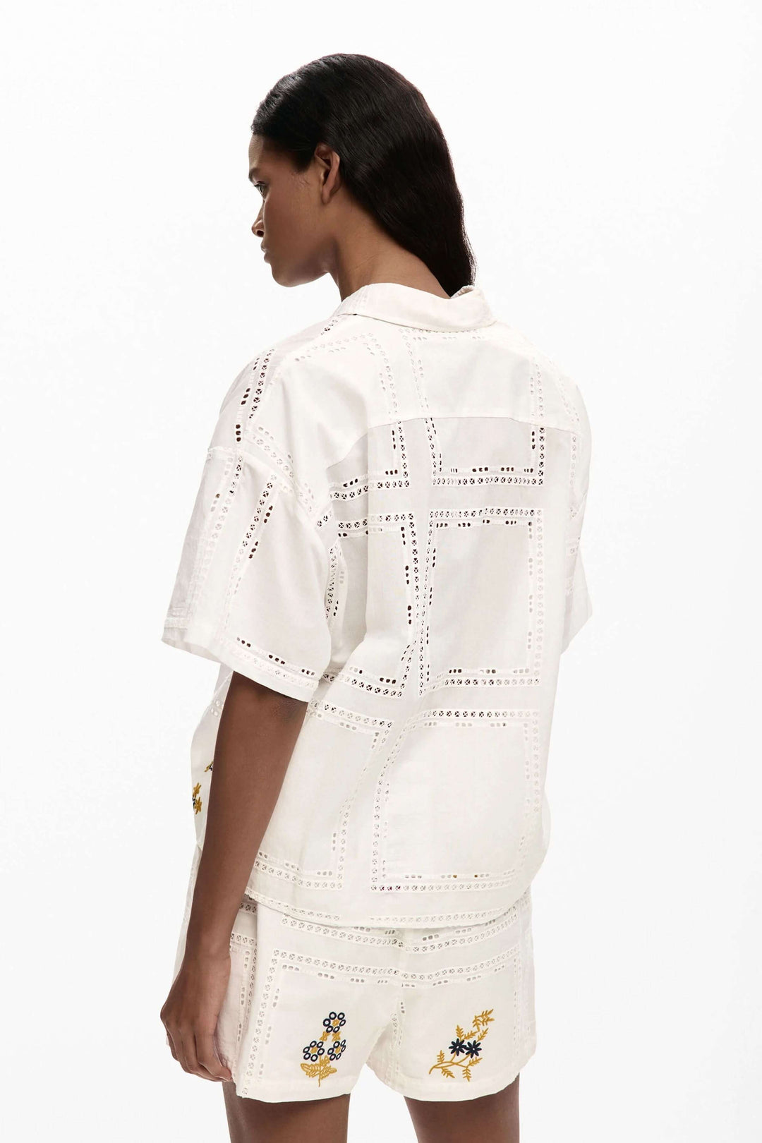 Femme portant une chemise fluide brodée à manches courtes avec broderies délicates, vue de dos