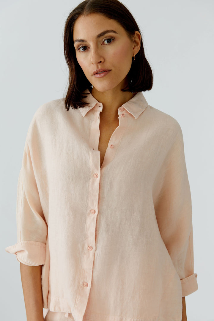 Femme portant une chemise fluide à manches longues élégante, idéale pour un style raffiné au quotidien.