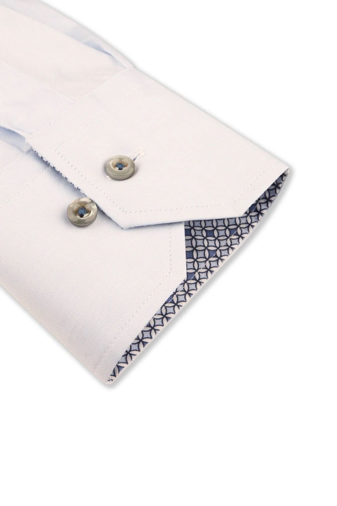 Détail d'une chemise habillée blanche avec poignets contrastés et boutons en nacre véritable.