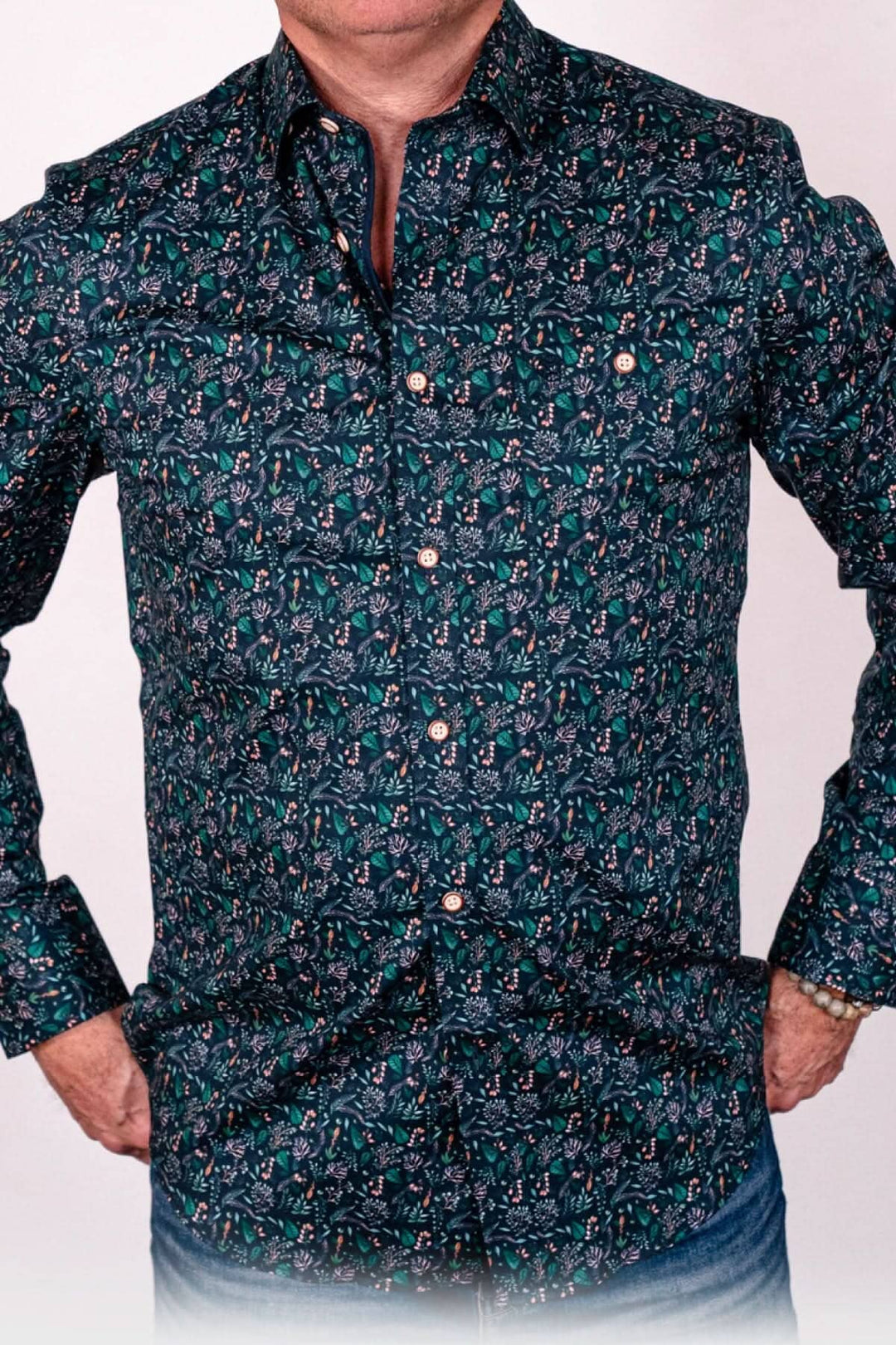 Chemise sport avec un imprimé de feuilles d'arbre en tones de vert et bleu, idéale pour un look élégant et naturel.