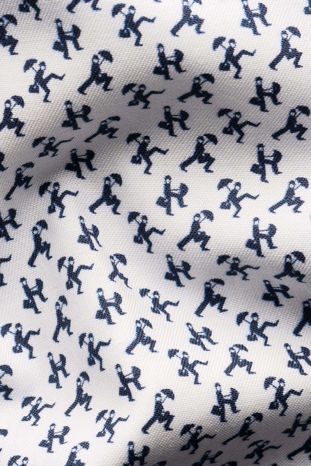 Détail du tissu de la chemise imprimé original avec silhouettes en mouvement, ajoutant une touche fantaisie à une pièce classique.