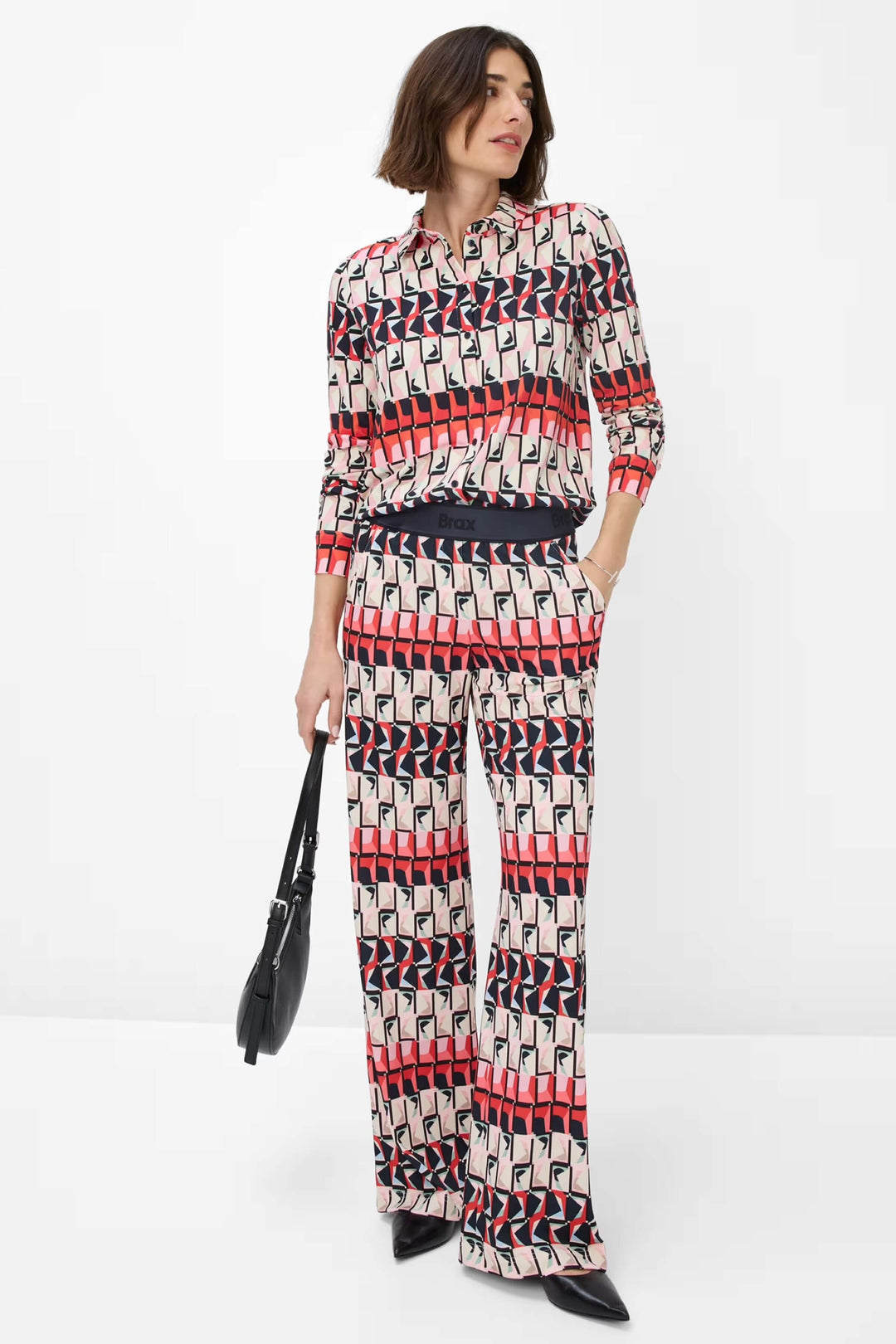 Chemise imprimée Celina avec motif géométrique, associée à un pantalon fluide pour un look chic.