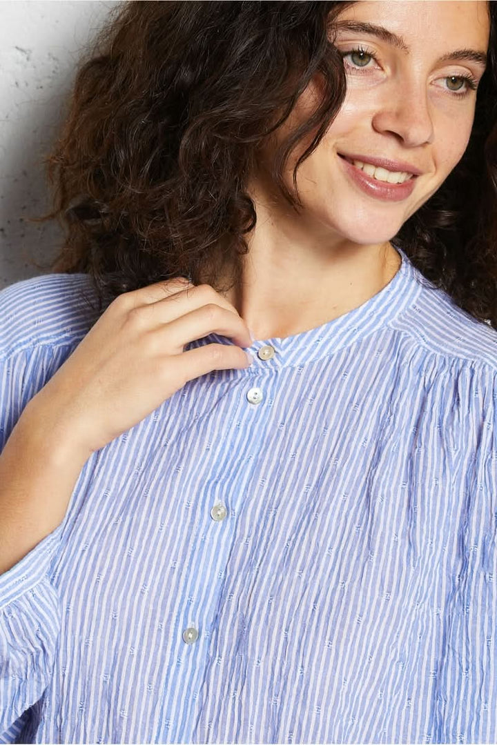 Femme portant une chemise intemporel rayée avec manches longues et col structuré.