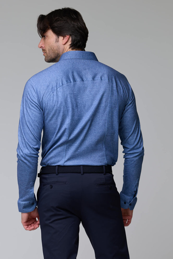 Chemise jersey texturé bleue à manches longues vue de dos, col structuré, portée par un homme, élégance moderne et confort décontracté.