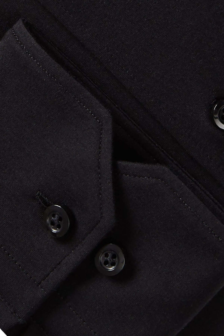 Détails d'une chemise élégante: tissu noir texturé avec boutons et poches soignées.