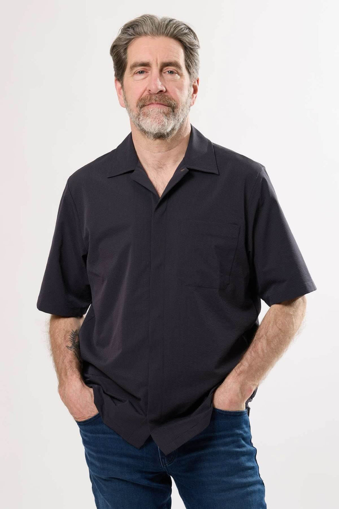 Chemise à manches courtes noire portée par un homme, idéale pour un look urbain raffiné en été.