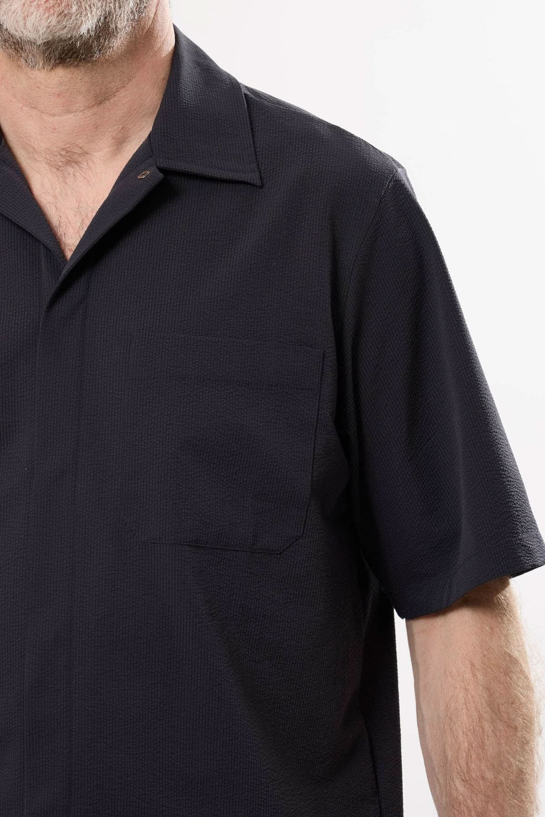 Chemise à manches courtes en tissu technique léger, col cubain ouvert et poche, idéale pour un look urbain.