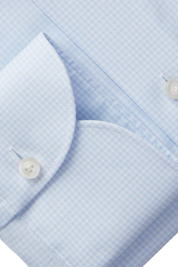 Chemise micro-carreaux bleue avec col classique et poignets à bouton, élégance discrète pour occasions professionnelles.