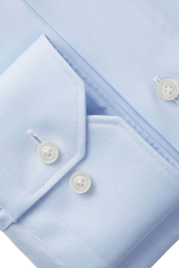 Chemise moderne en bleu clair avec col classique et boutons élégants, tissu doux et structuré.