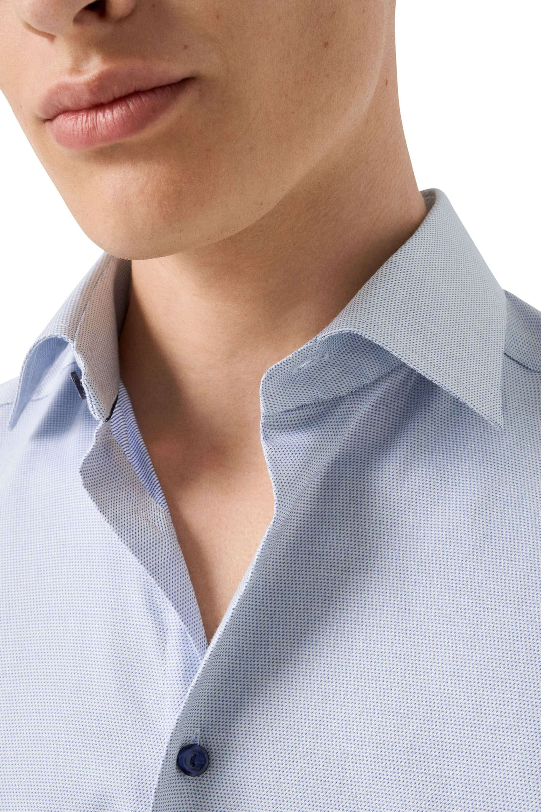 Chemise à motif discret avec col open et coupe ajustée, combinant confort et élégance moderne.