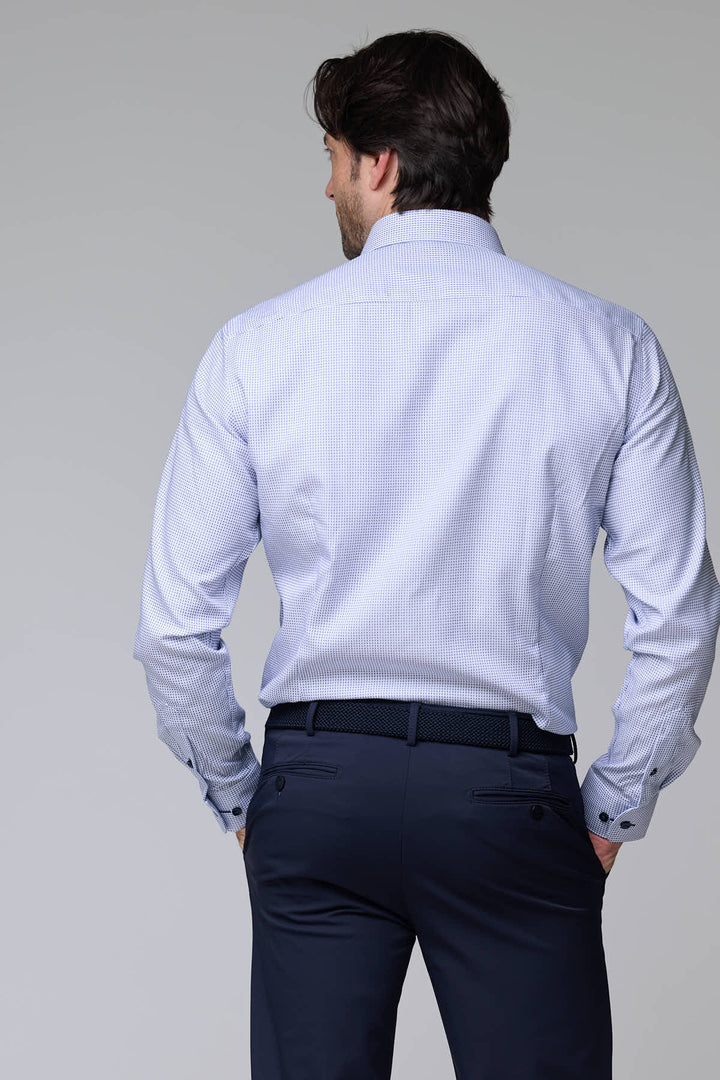 Homme portant une chemise à motif géométrique de dos, manches longues, coupe ajustée, avec un col structuré et boutons contrastants.