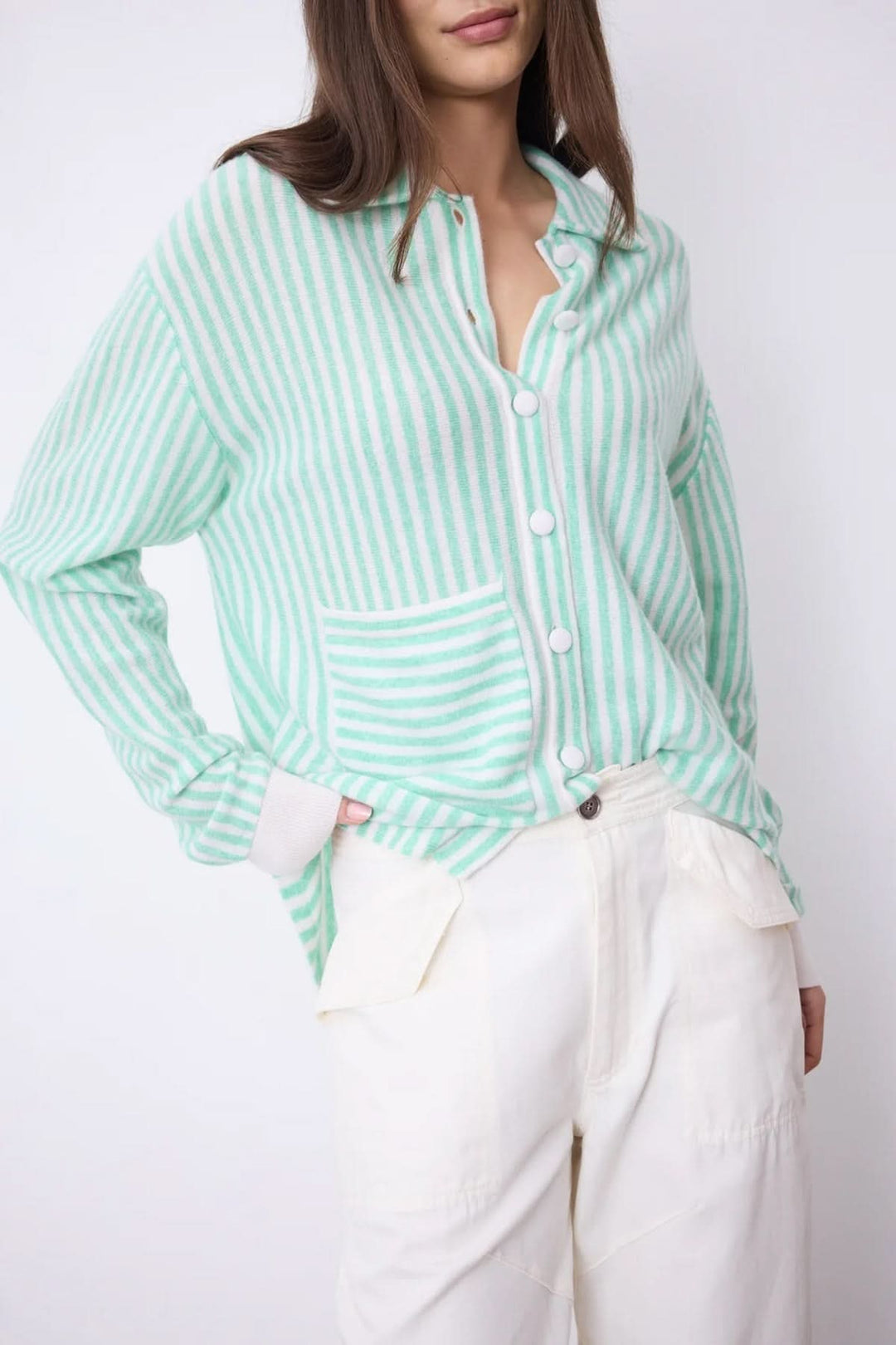 Chemise oversize en cachemire à rayures vertes et blanches avec poche plaquée et fermeture boutonnée, tenue élégante et contemporaine.