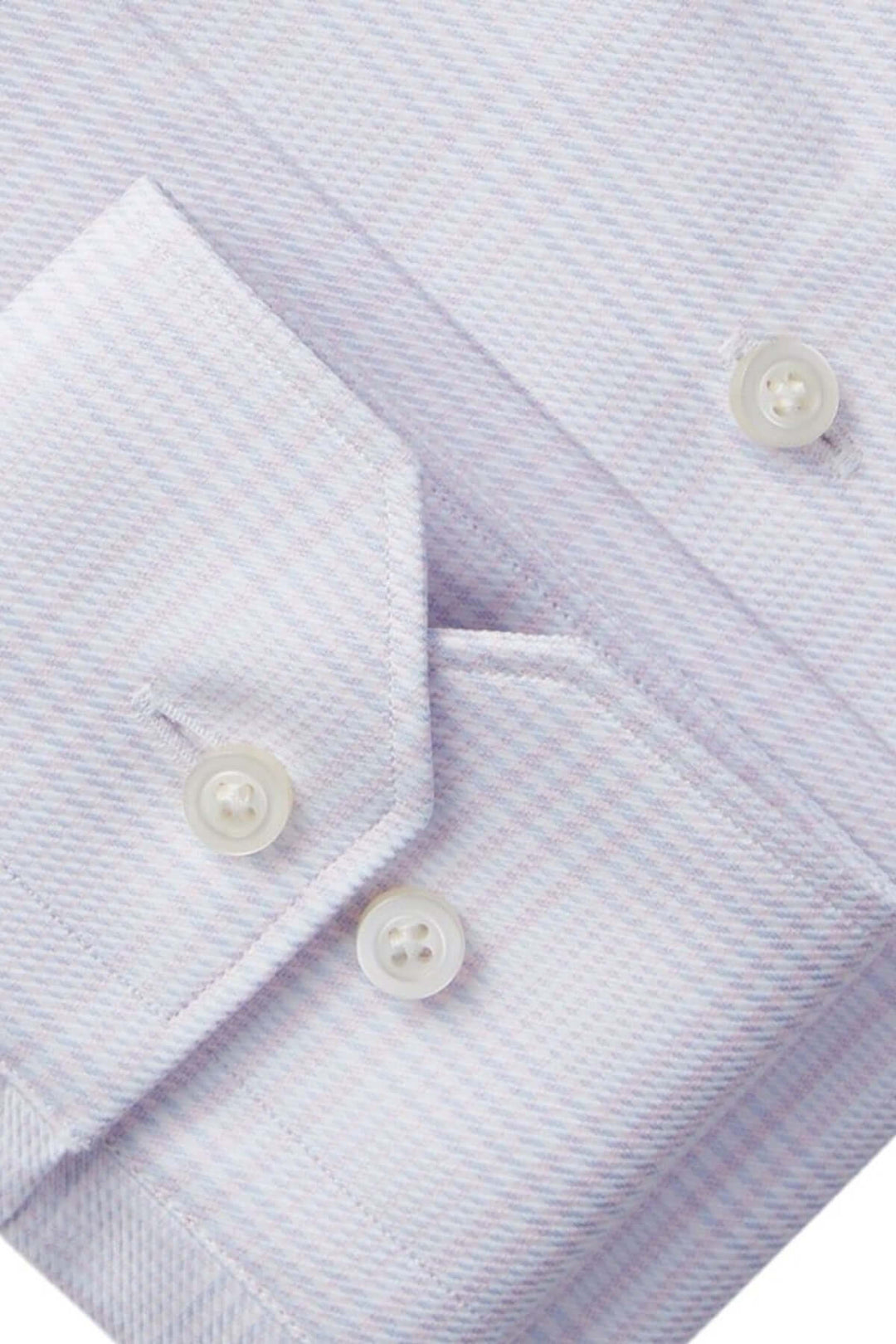 Détails de la chemise raffinée avec motif micro-carreaux et boutons nacrés sur les poignets ajustables.