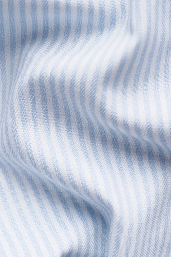 Motif de chemise rayée en coton et lyocell avec fines rayures bleues pour un look élégant et moderne.