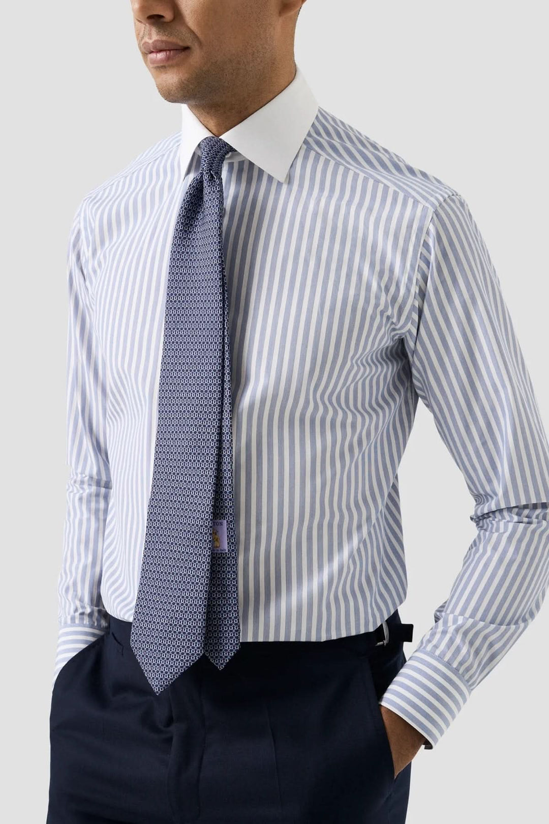 Chemise à rayures verticales avec col blanc, portée avec une cravate texturée, look professionnel élégant.