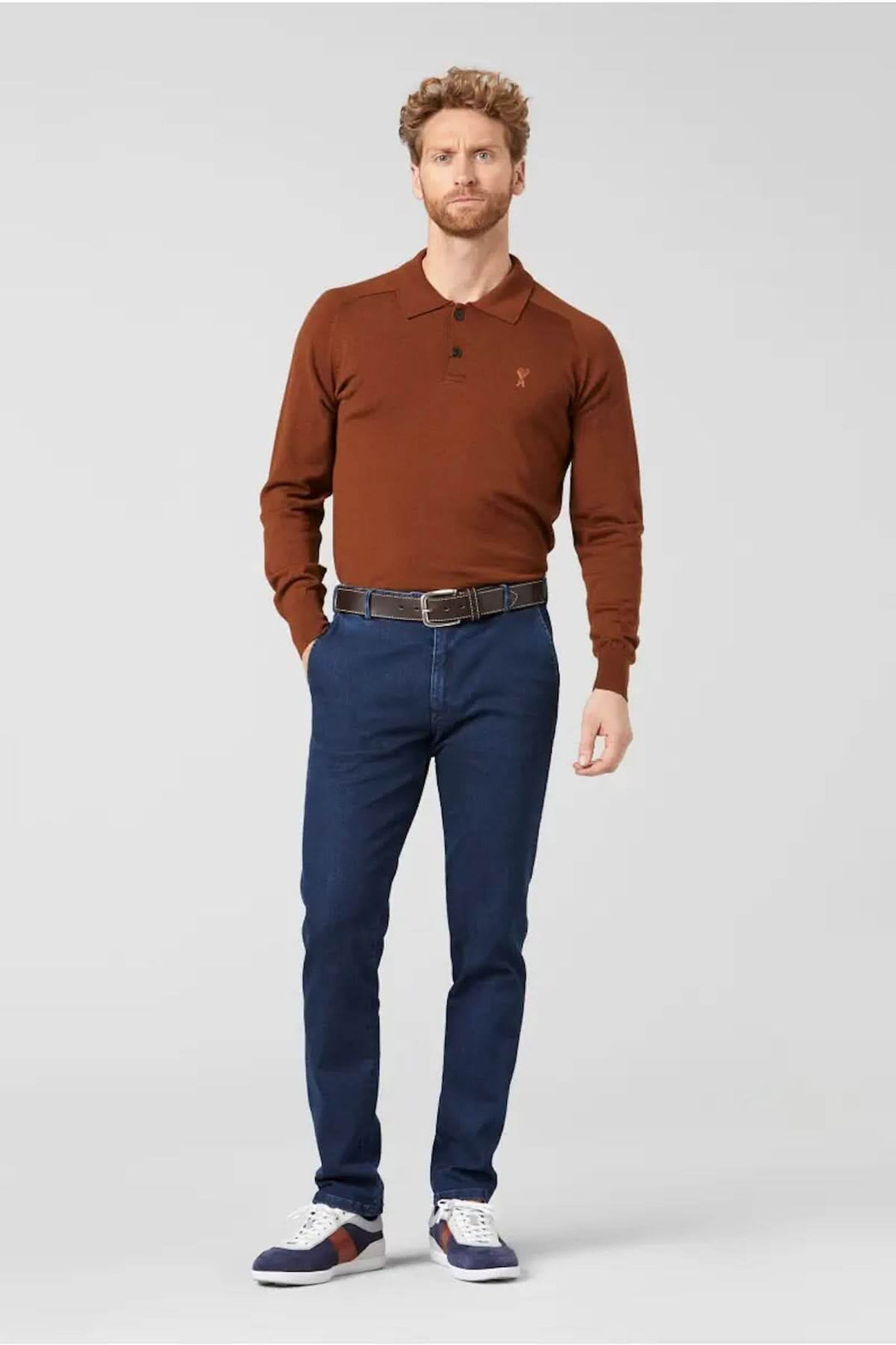 Homme portant un pull marron et un jean ajusté, style décontracté, idéal pour tenues quotidiennes.
