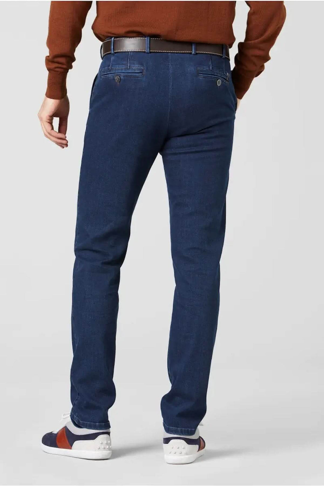 Jean Chino Oslo pour homme, coupe ajustée, en denim bleu avec jambe fuselée, porté avec un pull marron.