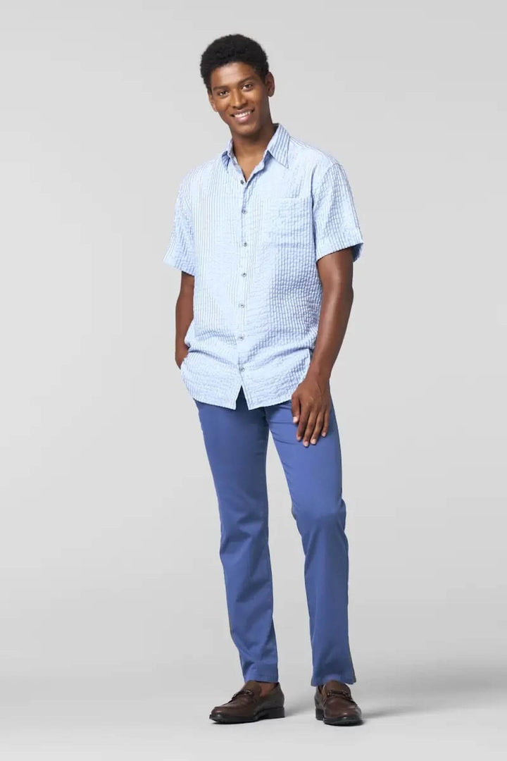 Homme souriant en chemise à manches courtes bleue et pantalon Chino Roma, look décontracté et élégant.