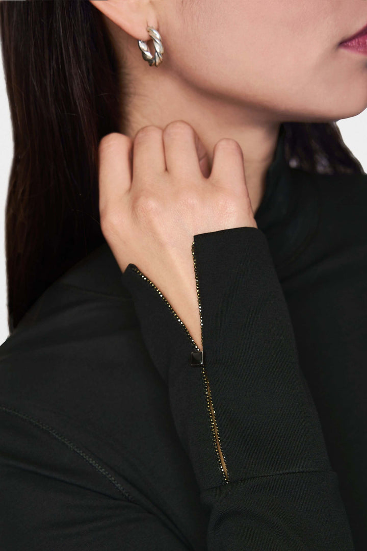 Détail du col roulé ajusté avec zip discret à la manche, mettant en valeur le style moderne et raffiné.