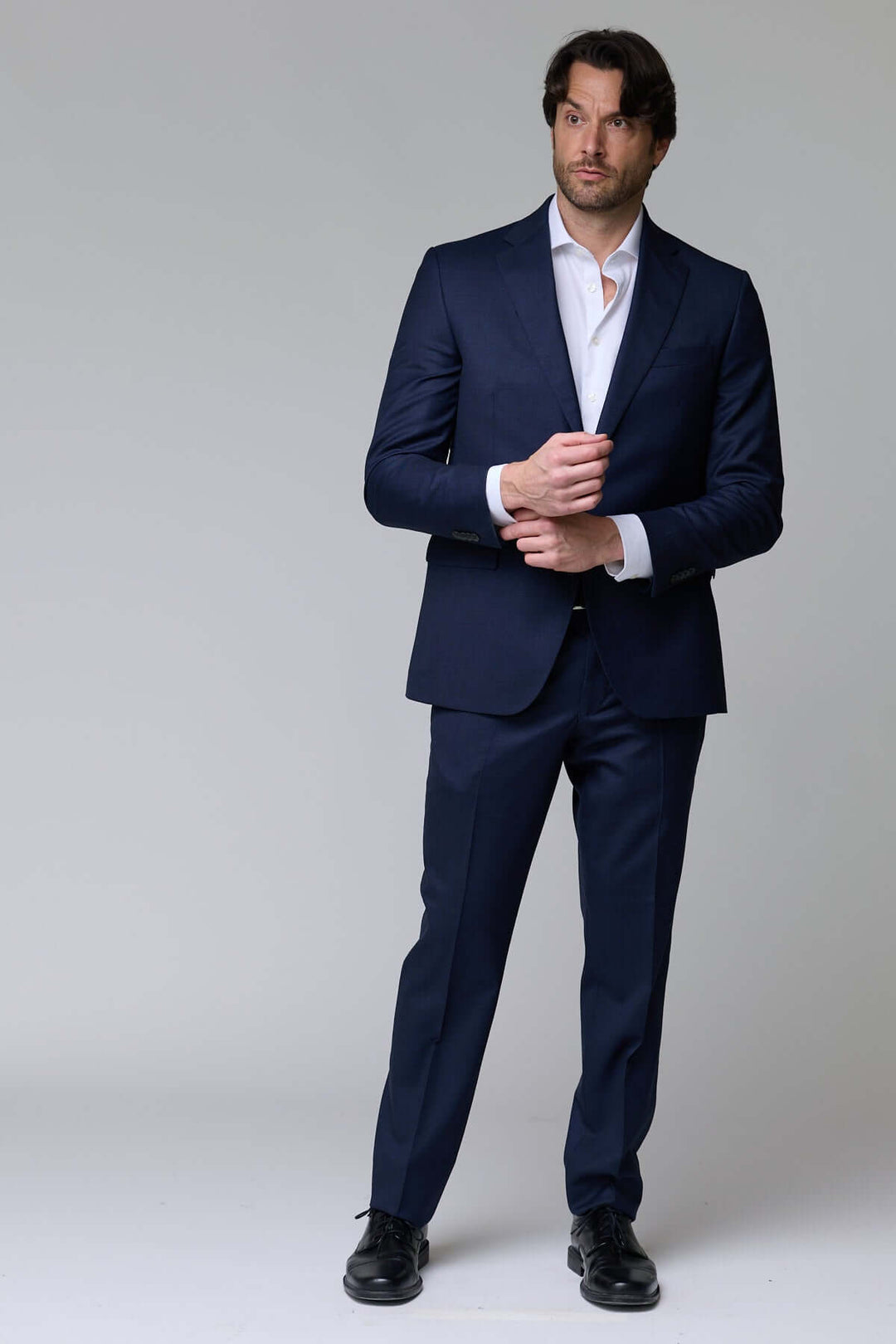 Homme portant un complet classique deux pièces, élégant et structuré, idéal pour le bureau ou événements formels.