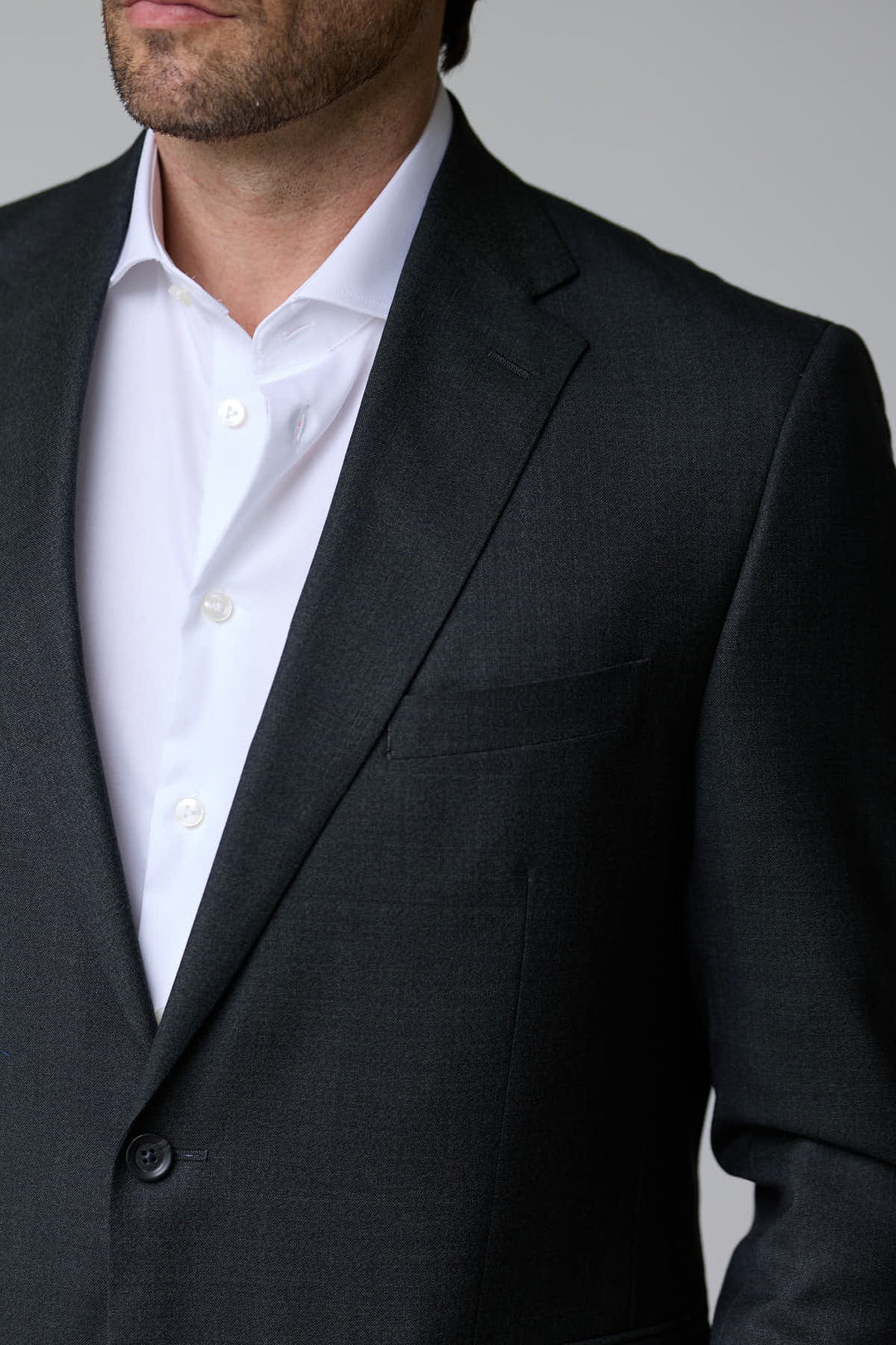 Homme portant un complet classique deux pièces, élégant et intemporel, en tissu structuré et ajusté, idéal pour les occasions formelles.