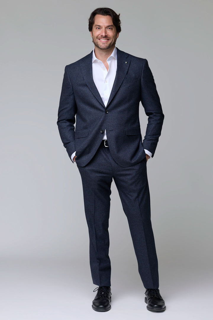 Homme portant un complet en laine texturée élégant et ajusté pour événements habillés et professionnels.