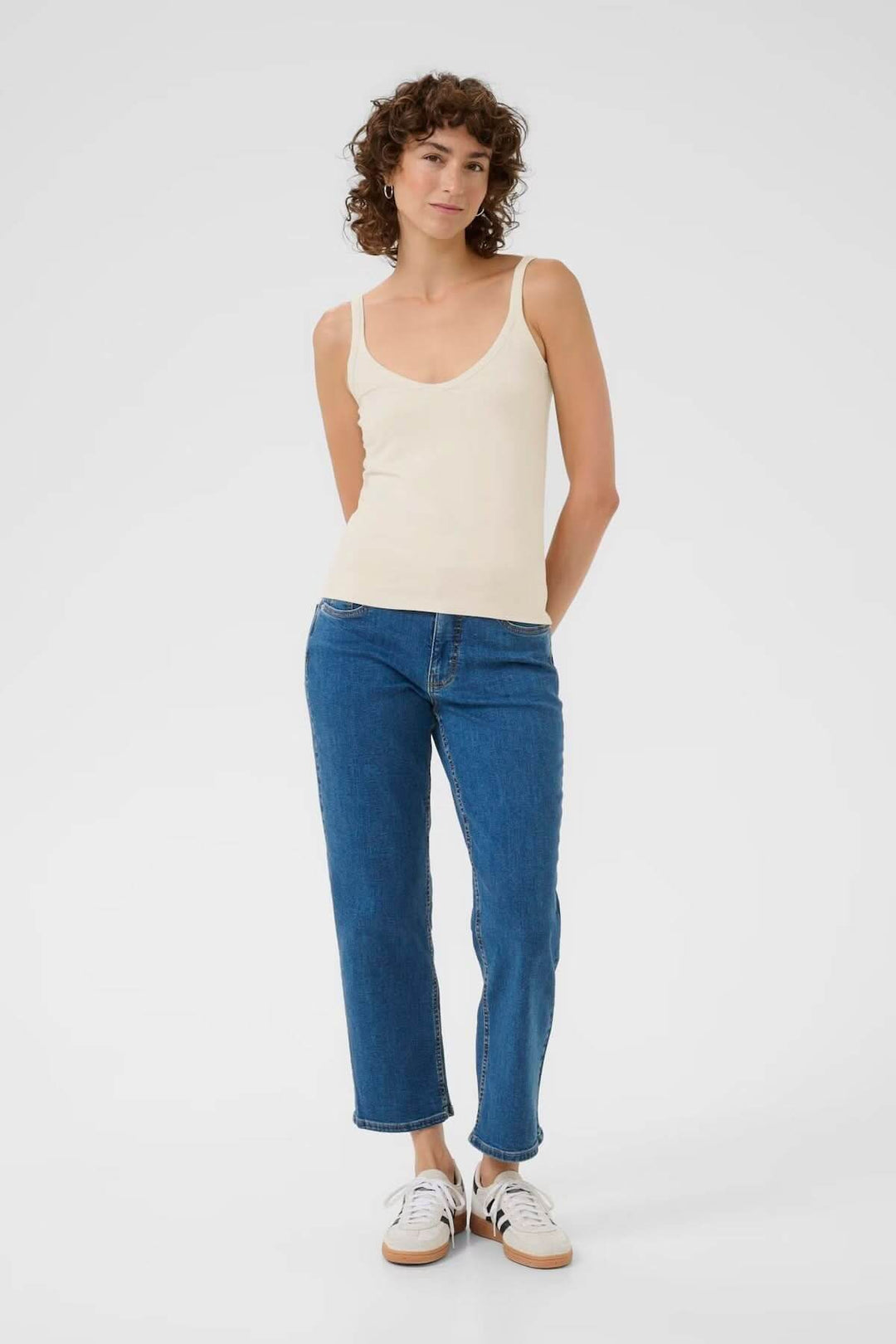 Débardeur à encolure arrondie associé à un jean bleu, affichant une coupe ajustée et élégante.