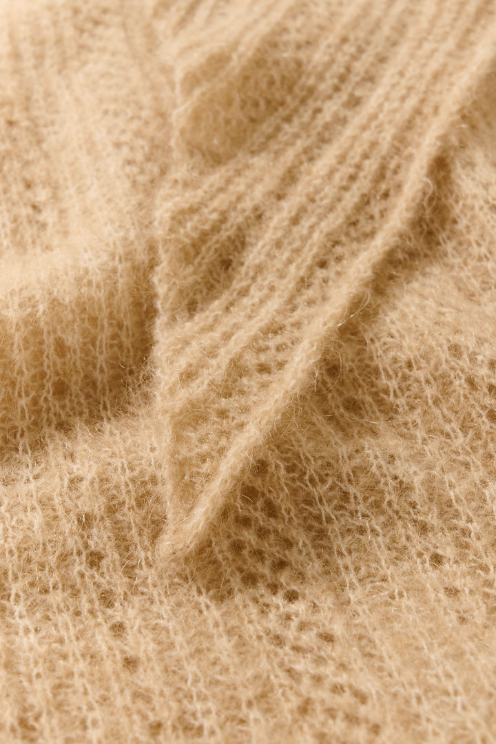 Détail du foulard Sizze en tricot léger couleur beige, montrant une texture douce et effilée.