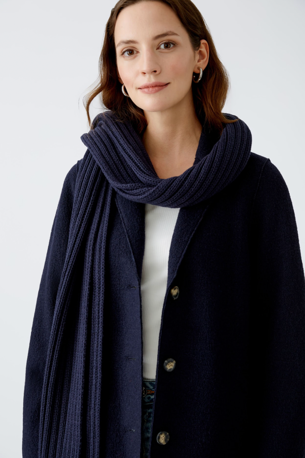 Femmes portant un foulard côtelé doux et volumineux avec un manteau classique noir.
