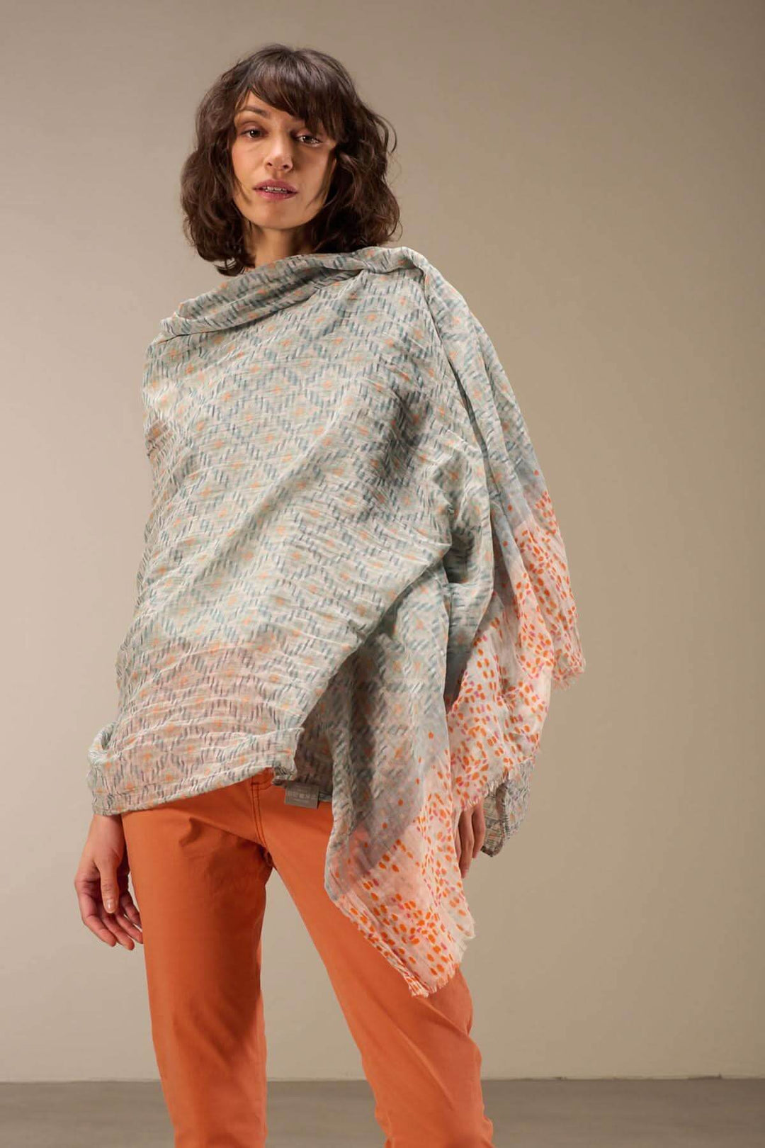 Foulard imprimé en coton bio, drapé autour du cou, ajoutant une touche sophistiquée à une tenue décontractée.