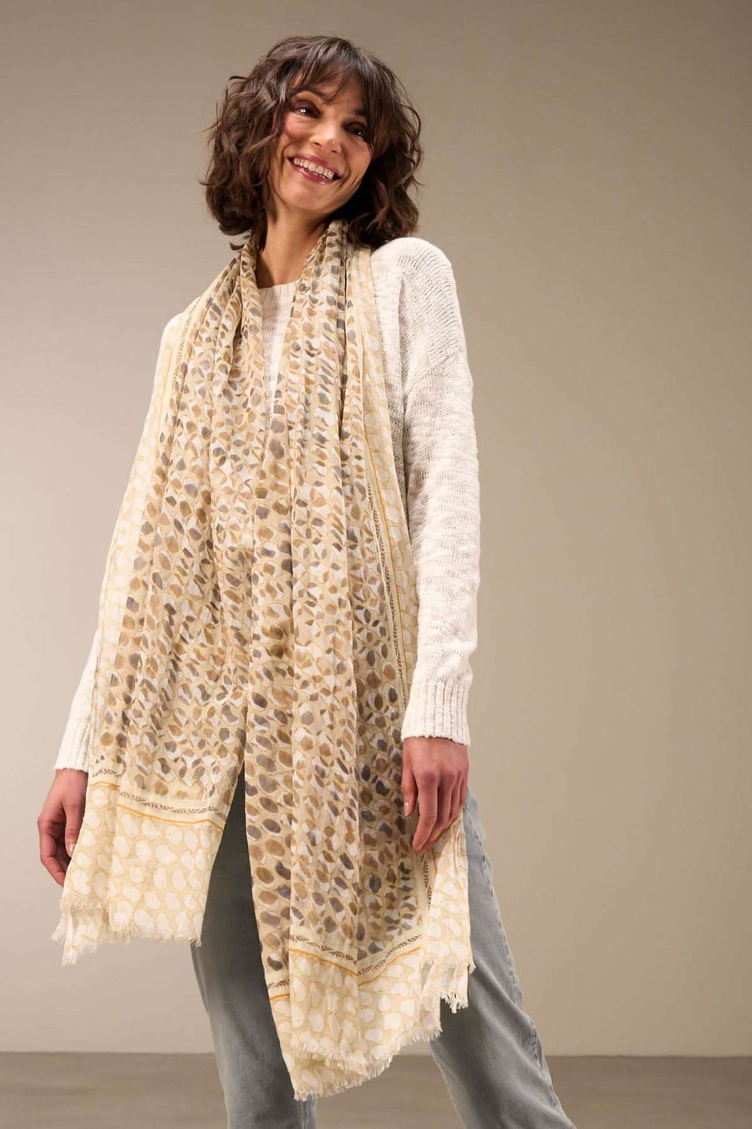 Foulard imprimé en coton bio aux motifs uniques, drapé élégamment autour du cou, ajoutant sophistication à toute tenue.