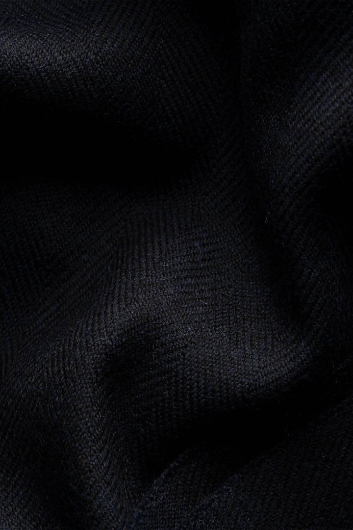 Texte subtil d'un foulard en laine à chevrons noir, mettant en avant sa texture élégante et confortable.