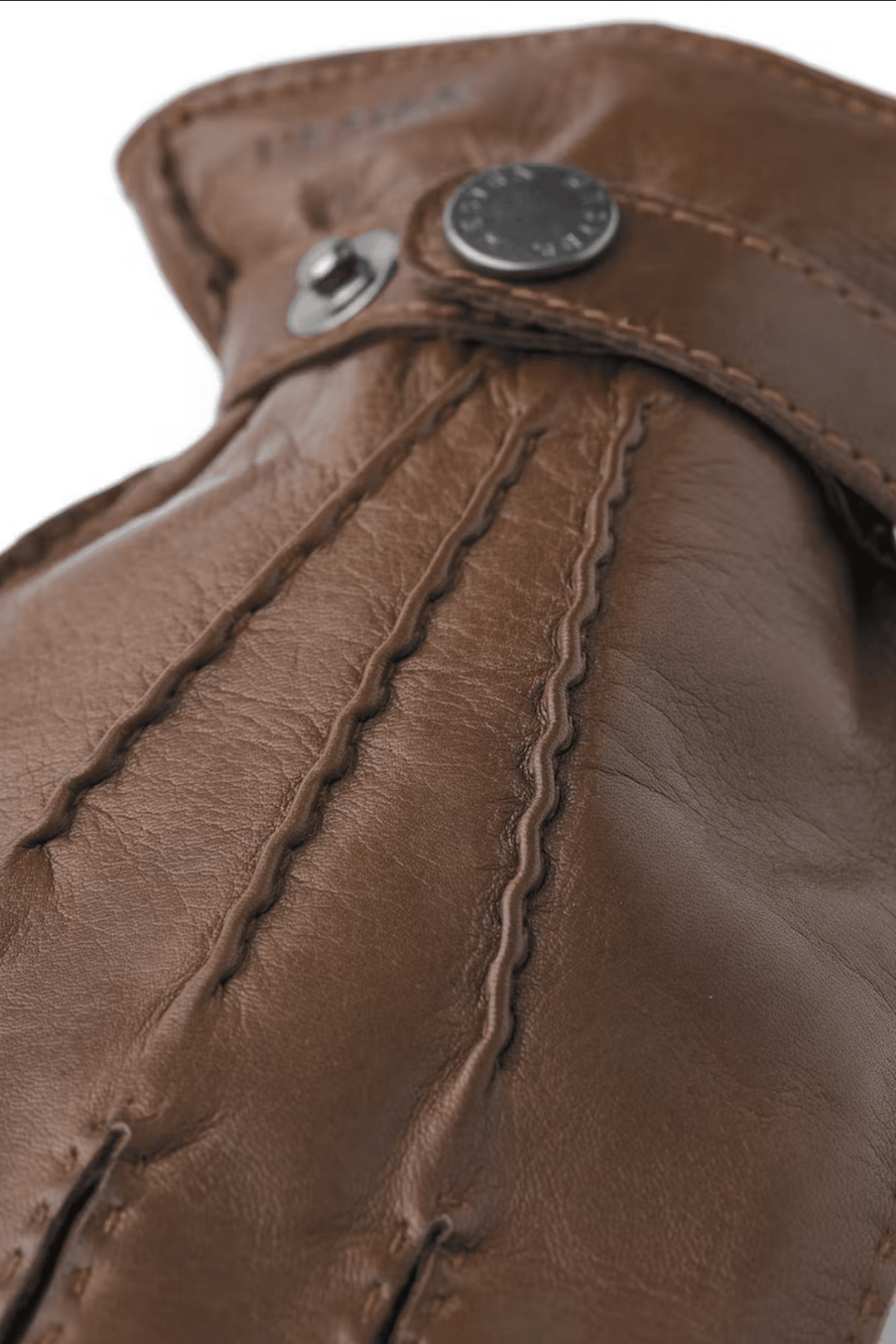 Détails en gros plan des gants de cuir Jake en nappa d'agneau italien marron avec bouton-pression.