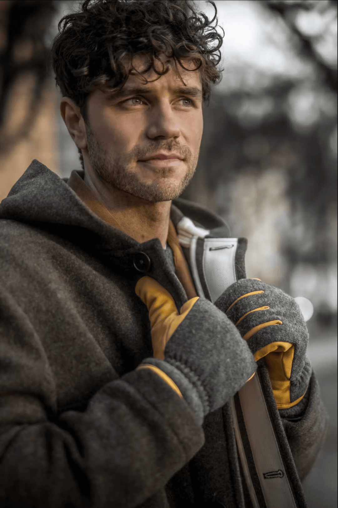Homme au style décontracté portant des gants de cuir Noah et un manteau en ville.