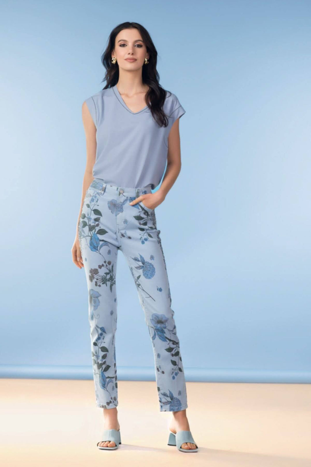 Femme portant un haut fluide col en V et un pantalon à imprimé floral, style moderne et élégant.