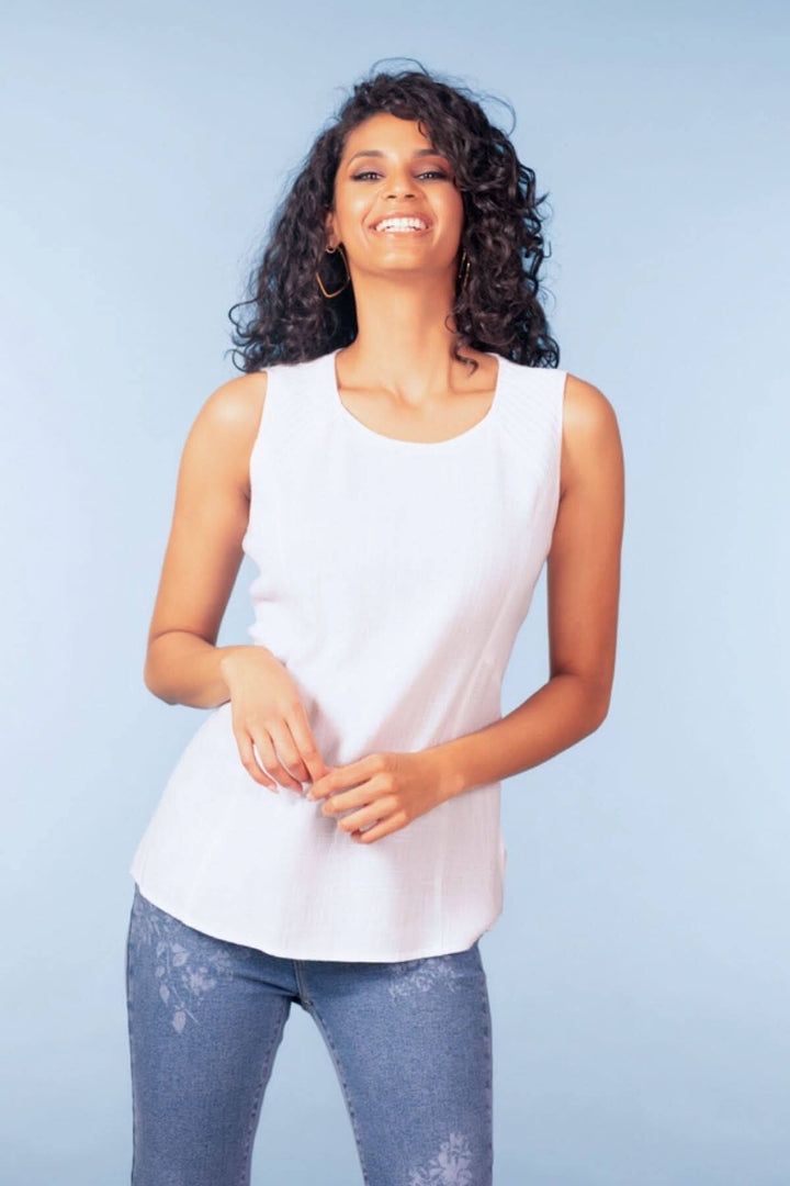 Femme portant un haut sans manches encolure ronde blanc, style épuré et coupe fluide pour un look soigné et polyvalent.